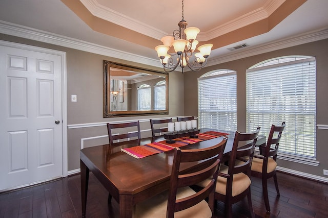 dining space with dark wood-style floors, a tray ceiling, visible vents, and a notable chandelier