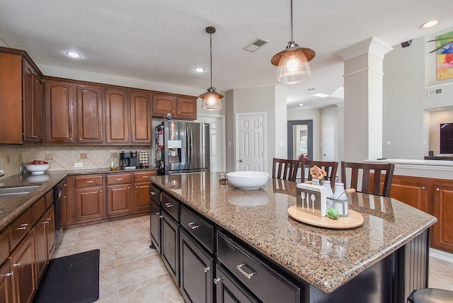 kitchen with a kitchen island, visible vents, stainless steel fridge with ice dispenser, tasteful backsplash, and decorative columns