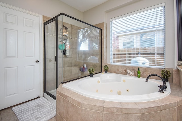 bathroom with a shower stall and a jetted tub