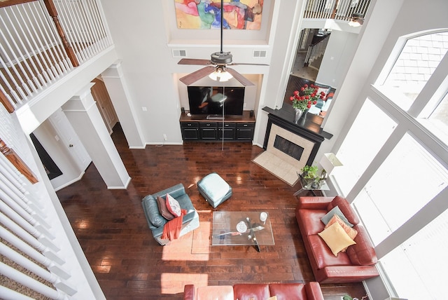 living room with hardwood / wood-style flooring, a high ceiling, and visible vents