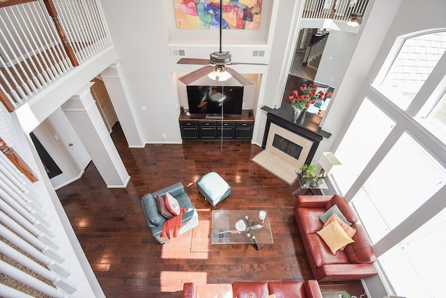 living room featuring hardwood / wood-style floors, a towering ceiling, and ceiling fan