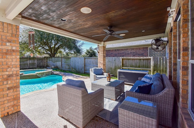 view of patio featuring a pool with connected hot tub, a fenced backyard, ceiling fan, and outdoor lounge area