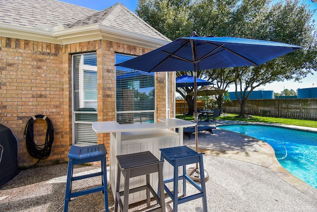 view of swimming pool with a fenced in pool, area for grilling, outdoor dry bar, fence, and a patio area