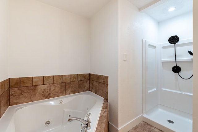 bathroom featuring tile patterned floors, baseboards, a whirlpool tub, and walk in shower