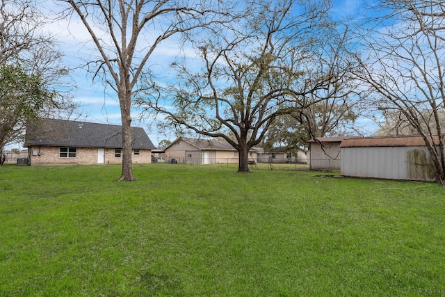 view of yard featuring a pole building, fence, and an outdoor structure