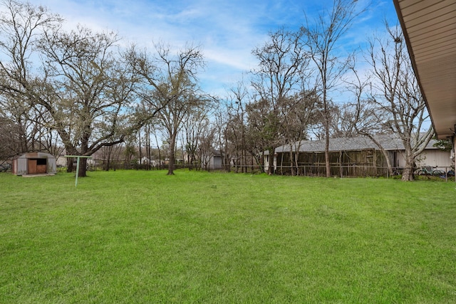 view of yard with a shed, an outdoor structure, and fence