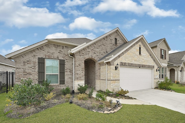 french provincial home with brick siding, a front lawn, fence, driveway, and an attached garage