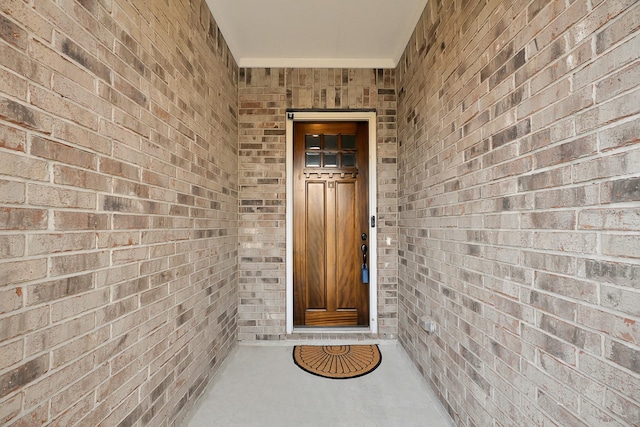 property entrance featuring brick siding