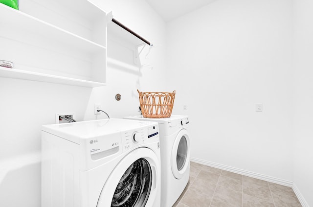 clothes washing area with laundry area, baseboards, and separate washer and dryer