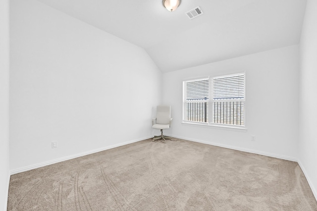 unfurnished room featuring visible vents, baseboards, carpet, and vaulted ceiling