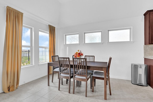 dining room with plenty of natural light, light tile patterned flooring, and baseboards