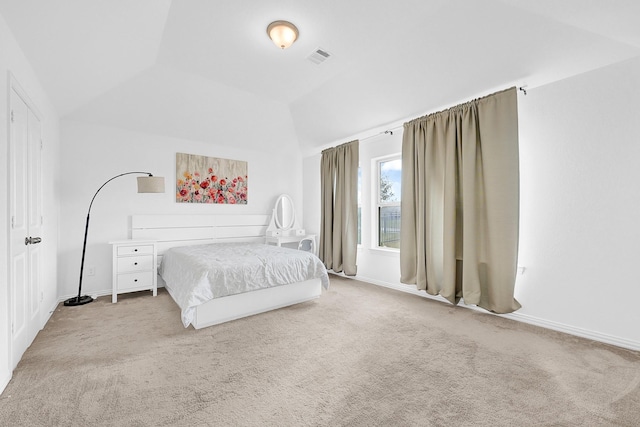 carpeted bedroom featuring lofted ceiling, baseboards, and visible vents