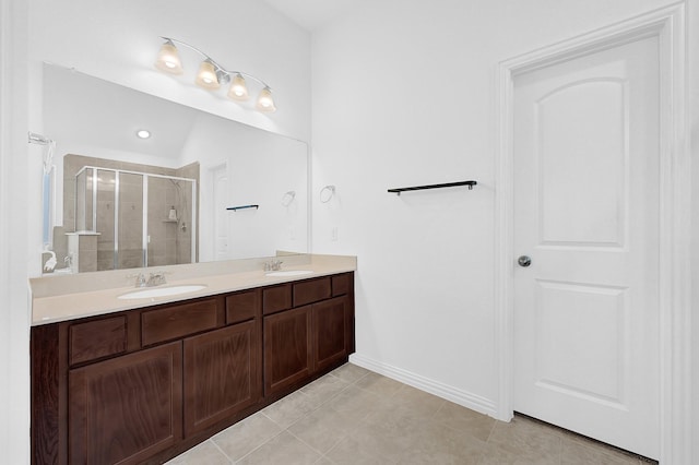 full bath featuring double vanity, tile patterned flooring, a shower stall, and a sink