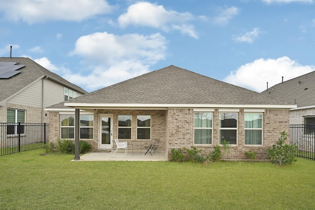 back of house with a yard, a patio area, brick siding, and a fenced backyard