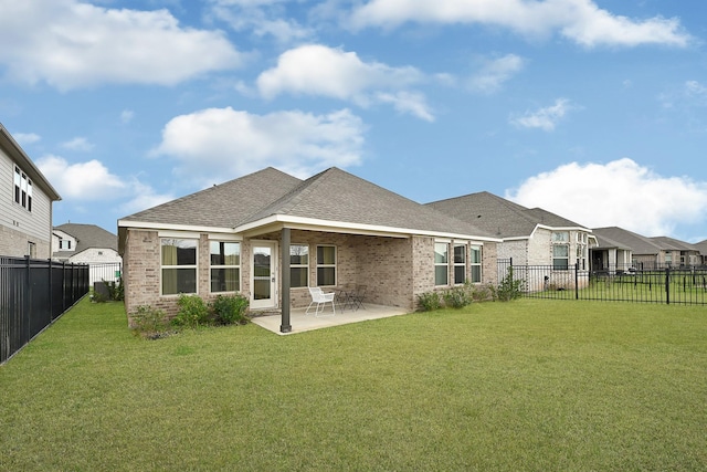 back of property with brick siding, a patio area, a lawn, and a fenced backyard