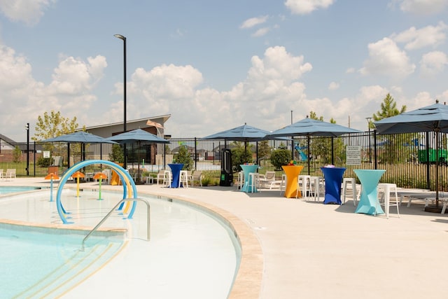 community pool with a patio and fence