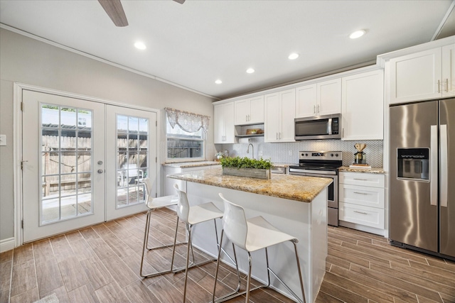 kitchen with white cabinetry, appliances with stainless steel finishes, backsplash, and french doors