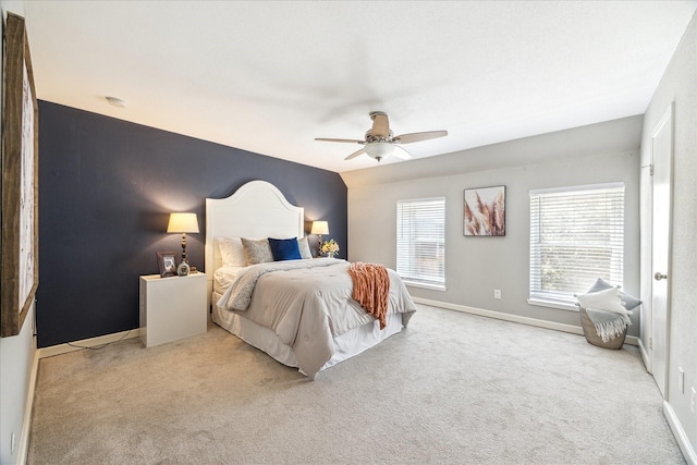 bedroom with a ceiling fan, light colored carpet, and baseboards