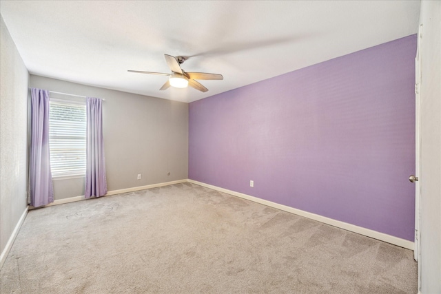 spare room featuring carpet flooring, a ceiling fan, and baseboards