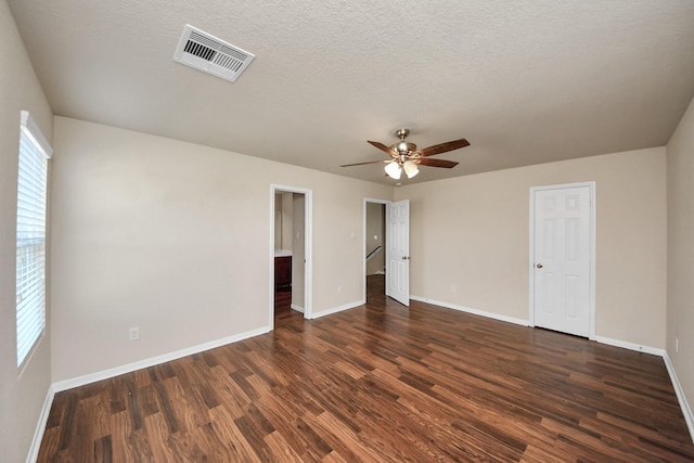 unfurnished bedroom with baseboards, visible vents, and dark wood-type flooring