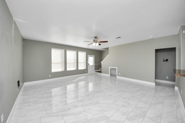 unfurnished living room featuring marble finish floor, stairway, visible vents, and baseboards