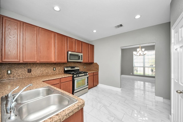 kitchen with marble finish floor, visible vents, backsplash, appliances with stainless steel finishes, and a sink