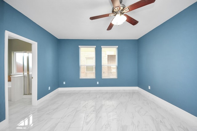 empty room with a ceiling fan and baseboards