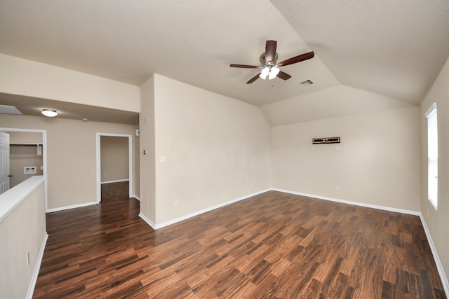 unfurnished room with lofted ceiling, baseboards, visible vents, and dark wood-type flooring