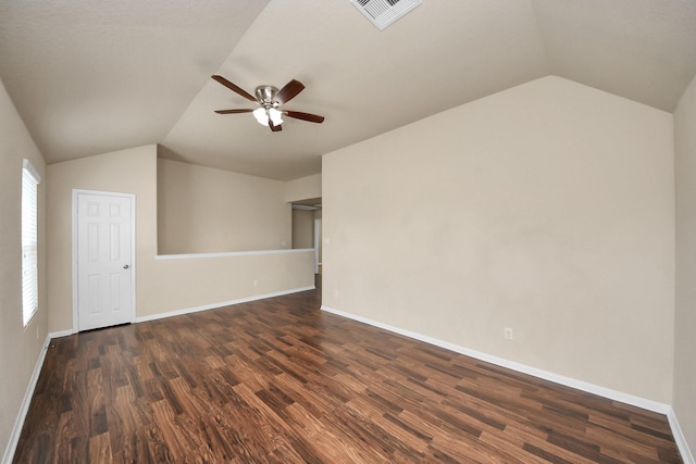 unfurnished living room featuring vaulted ceiling, dark wood finished floors, visible vents, and baseboards