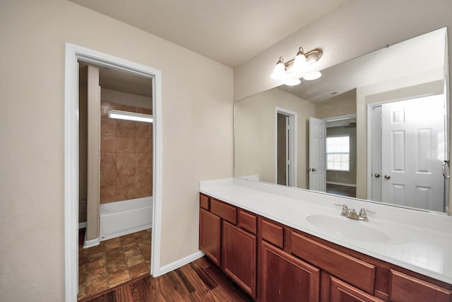 full bathroom featuring vanity, baseboards, and wood finished floors