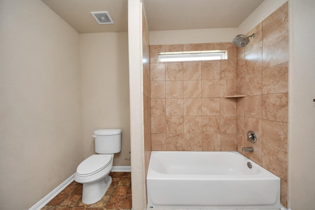 bathroom with toilet, baseboards, visible vents, and shower / washtub combination