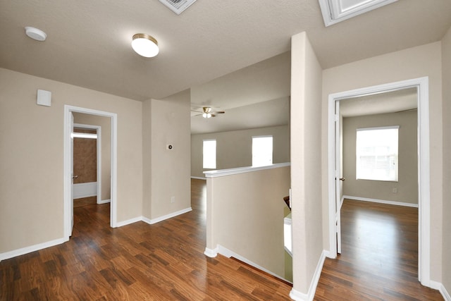 hallway with a wealth of natural light, baseboards, dark wood-type flooring, and an upstairs landing