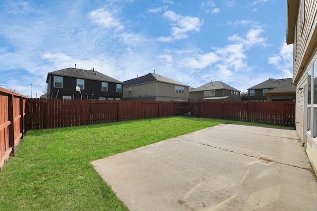 view of yard with a residential view, a fenced backyard, and a patio