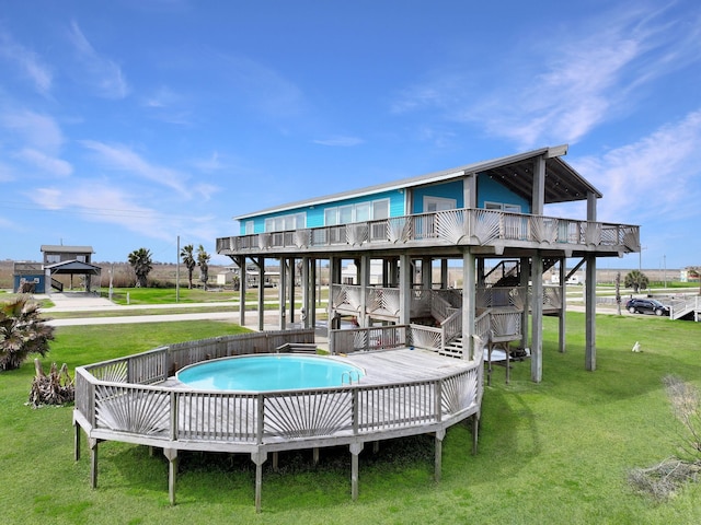 rear view of property featuring a lawn and a deck