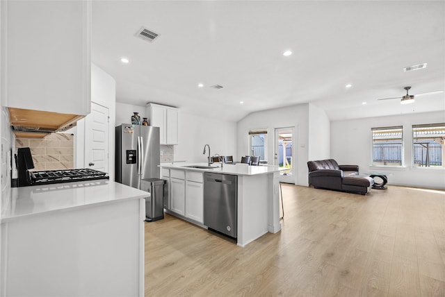 kitchen featuring open floor plan, appliances with stainless steel finishes, a wealth of natural light, and visible vents