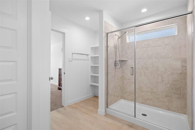 bathroom with a stall shower, recessed lighting, wood finished floors, and baseboards