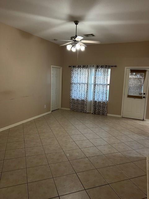 unfurnished room featuring light tile patterned floors, baseboards, visible vents, and a ceiling fan