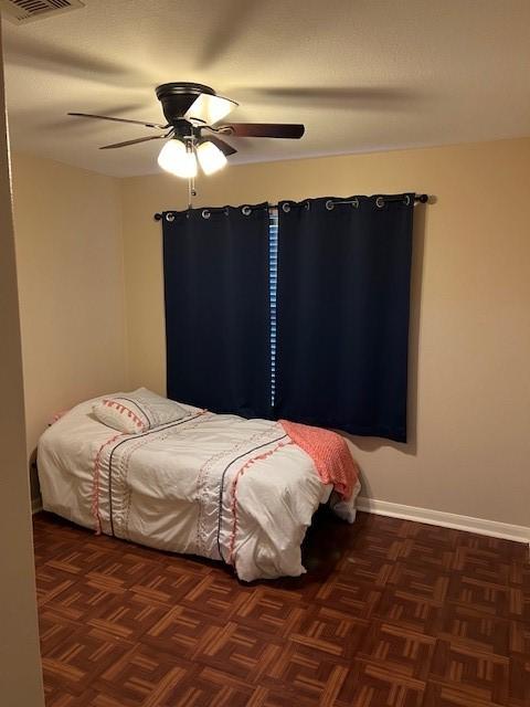 bedroom with a ceiling fan, visible vents, and baseboards