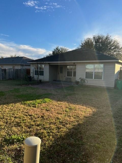 back of house with a lawn and fence