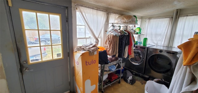 washroom featuring washing machine and dryer, laundry area, a textured ceiling, and tile patterned floors