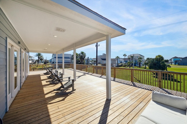 wooden deck featuring a residential view and a yard