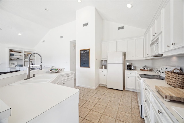 kitchen with lofted ceiling, visible vents, white cabinets, a sink, and white appliances