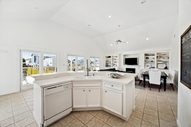 kitchen with built in shelves, a fireplace, a sink, light countertops, and dishwasher