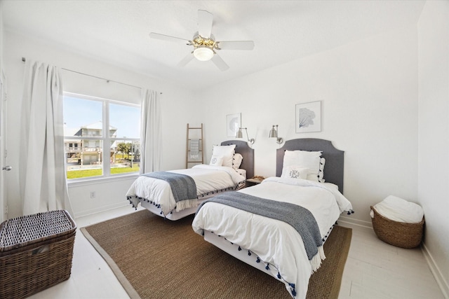 bedroom with a ceiling fan and baseboards