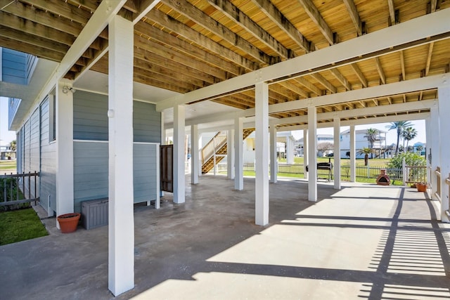 view of patio featuring stairway and fence