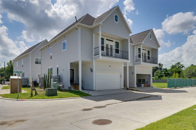 view of front of home featuring driveway, an attached garage, and a balcony