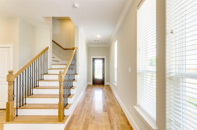 entryway featuring stairs, crown molding, baseboards, and wood finished floors