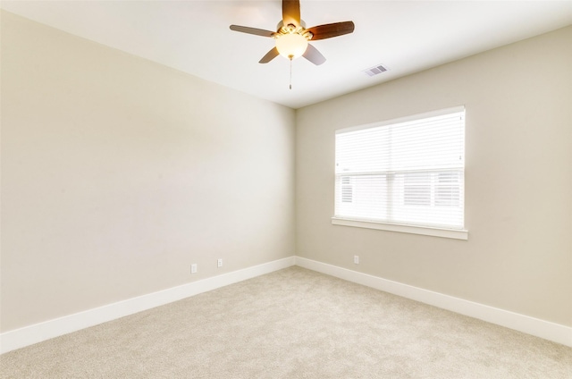 unfurnished room featuring visible vents, a ceiling fan, light colored carpet, and baseboards