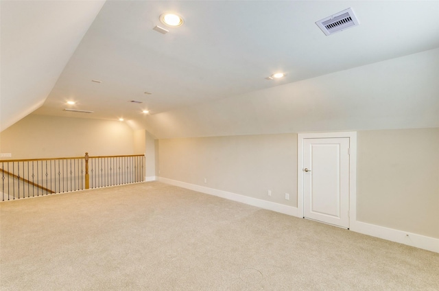 additional living space with carpet floors, lofted ceiling, visible vents, and baseboards