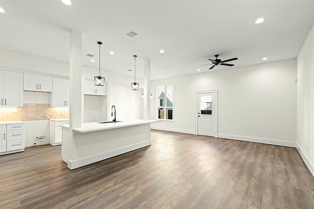 kitchen with a sink, a center island with sink, recessed lighting, wood finished floors, and open floor plan
